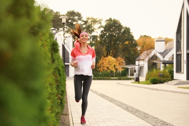 Photo of Beautiful sporty woman running on street. Healthy lifestyle