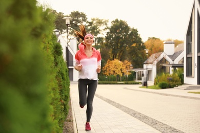 Beautiful sporty woman running on street. Healthy lifestyle