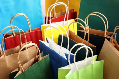 Photo of Colorful paper shopping bags as background, closeup