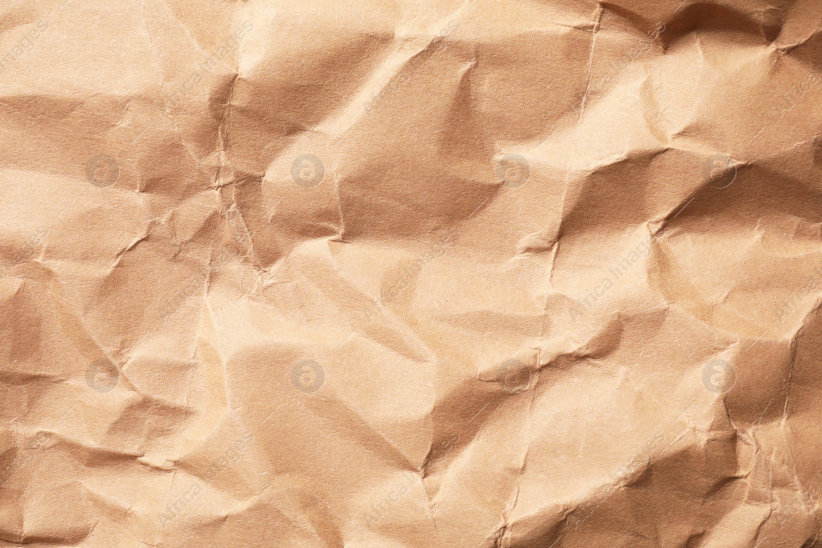 Photo of Crumpled kraft paper sheet as background, top view