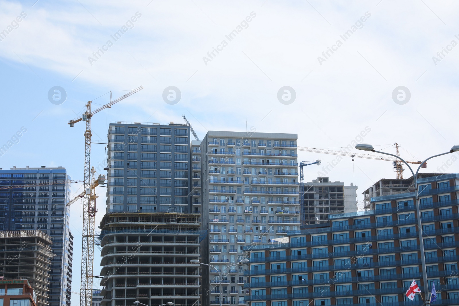 Photo of Batumi, Georgia - June 06, 2022: View of construction site with tower cranes near unfinished and modern buildings outdoors