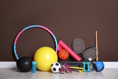 Different sports equipment near brown wall indoors