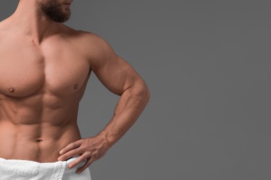 Muscular man showing abs on grey background, closeup and space for text. Sexy body