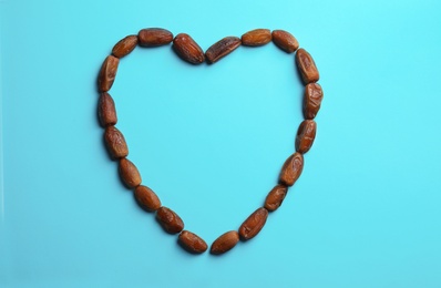 Photo of Frame made of sweet dried date fruits on color background, top view with space for text