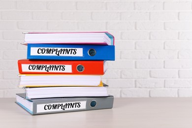 Image of Colorful folders with Complaints labels on table, space for text