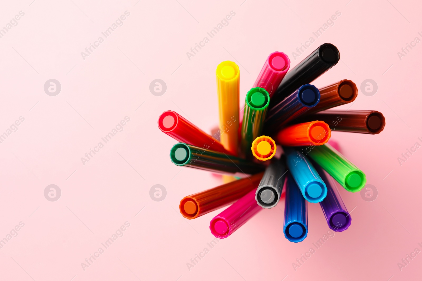 Photo of Many bright markers on pink background, top view. Space for text