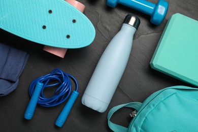 Different sports equipment on black table, flat lay