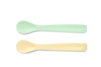 Plastic spoons isolated on white, top view. Serving baby food