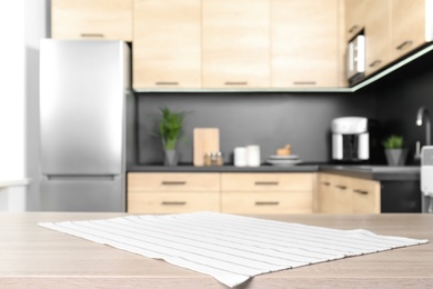 Photo of Napkin on wooden table in kitchen. Mockup for design