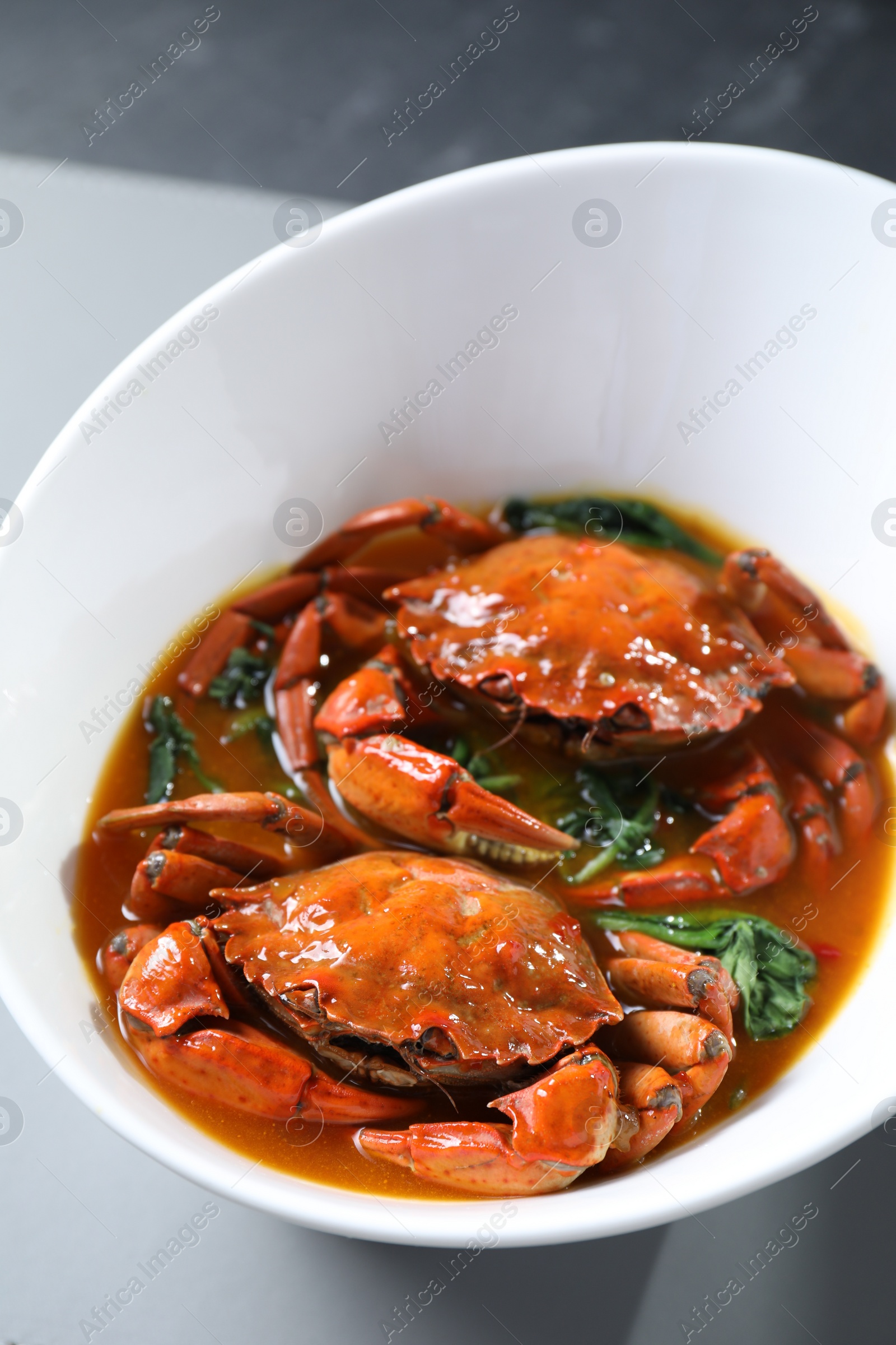 Photo of Delicious boiled crabs with sauce on table, closeup