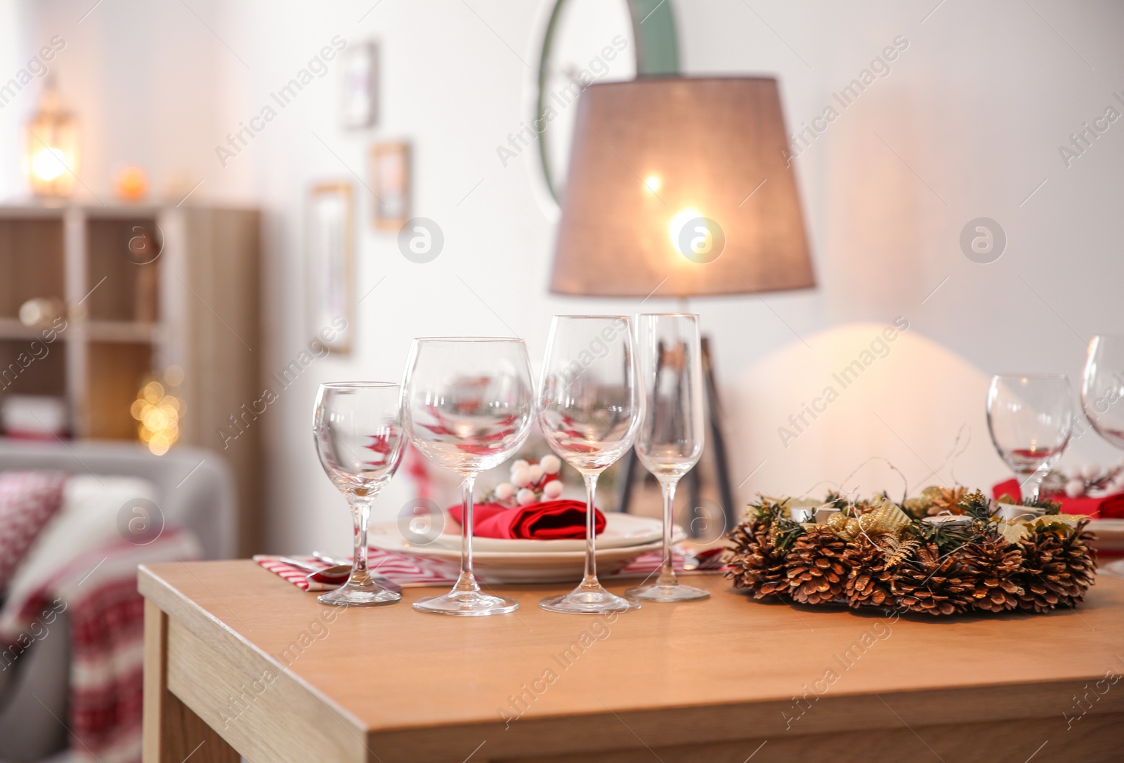 Photo of Set of dinnerware and Christmas wreath on table indoors