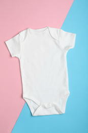 Photo of Child's bodysuit on light blue and pink background, top view