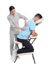 Photo of Man receiving massage in modern chair on white background