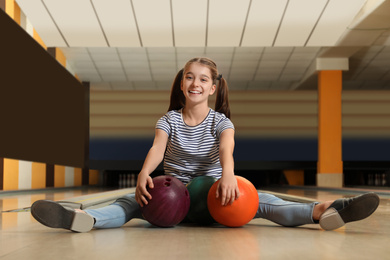 Preteen girl with balls in bowling club