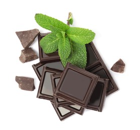 Tasty dark chocolate pieces with mint on white background, top view