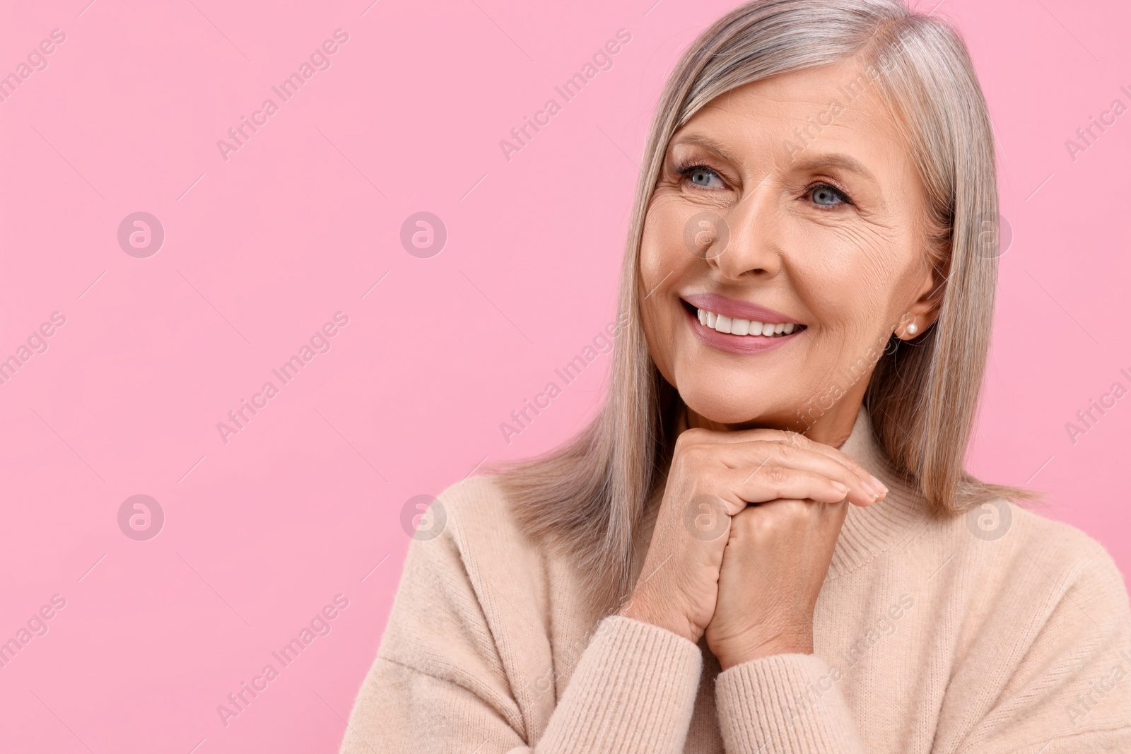 Photo of Portrait of beautiful middle aged woman on pink background, space for text