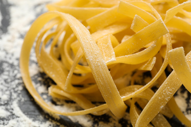 Tagliatelle pasta on grey table, closeup view