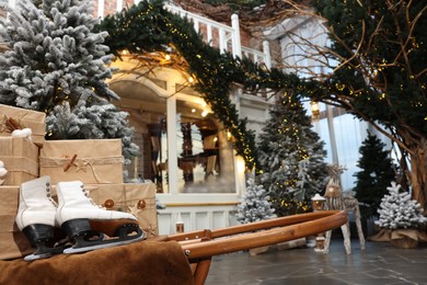 Photo of Beautiful Christmas trees, many gift boxes, skates and festive decor indoors. Interior design