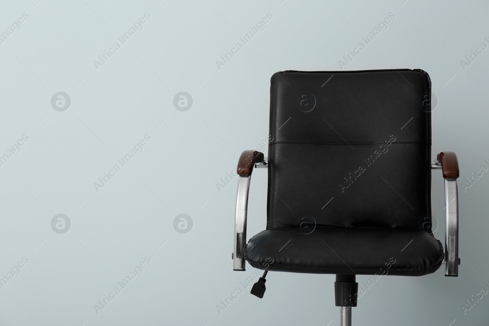 Photo of Comfortable office chair on light background. Space for text