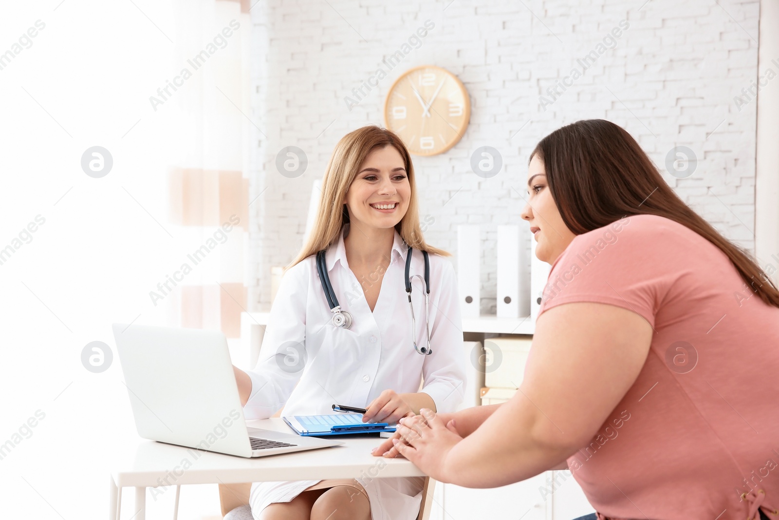 Photo of Female doctor consulting overweight woman in clinic