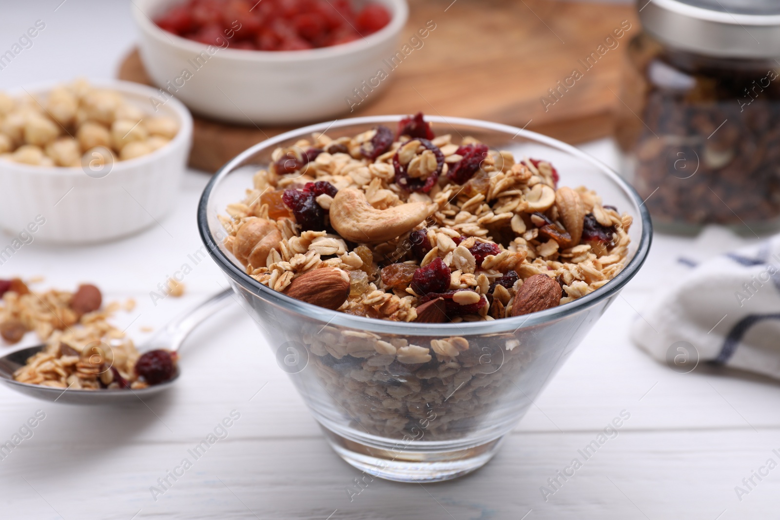 Photo of Bowl of tasty granola on white wooden table