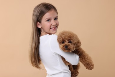 Photo of Little child with cute puppy on beige background. Lovely pet