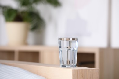 Glass of pure water on wooden table indoors. Space for text