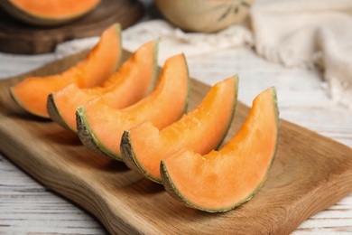 Slices of ripe cantaloupe melon in wooden tray on wooden table