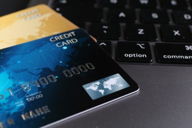 Photo of Two plastic credit cards on laptop, closeup