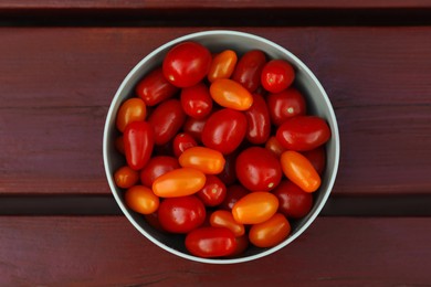 Photo of Bowl with fresh tomatoes on wooden table, top view