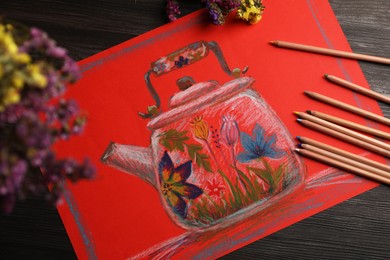 Photo of Colorful pastel pencils, flowers and beautiful painting on wooden table, top view
