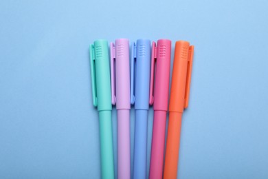 Many colorful markers on light blue background, flat lay