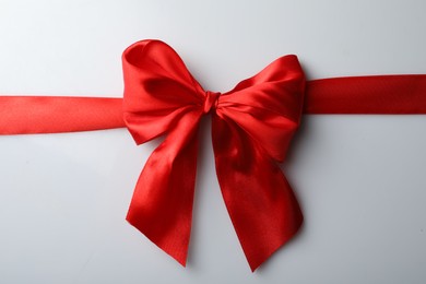 Photo of Red bow and ribbon on white background, top view