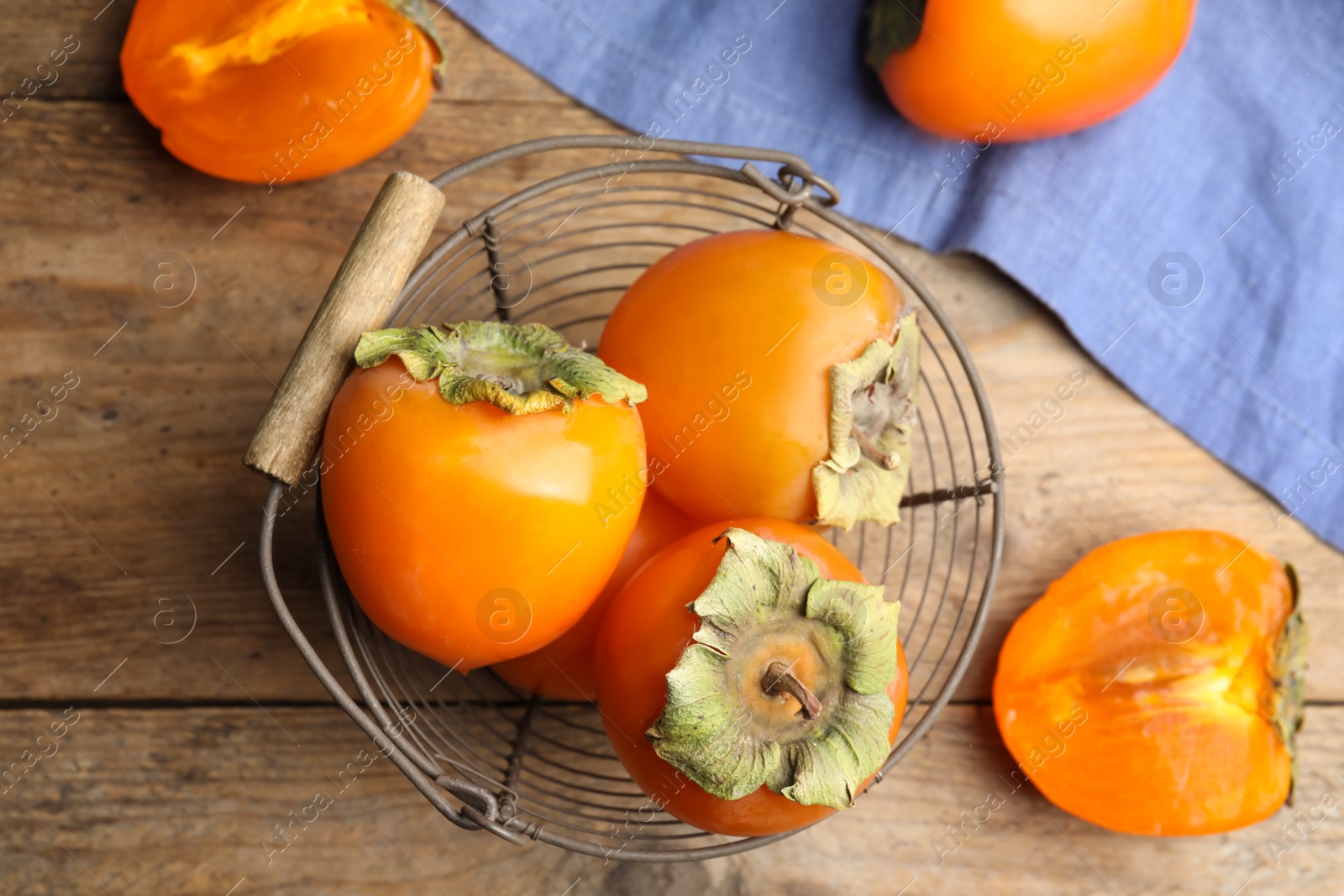 Photo of Delicious fresh persimmons on wooden table, flat lay