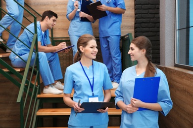 Young smiling medical students in university hall