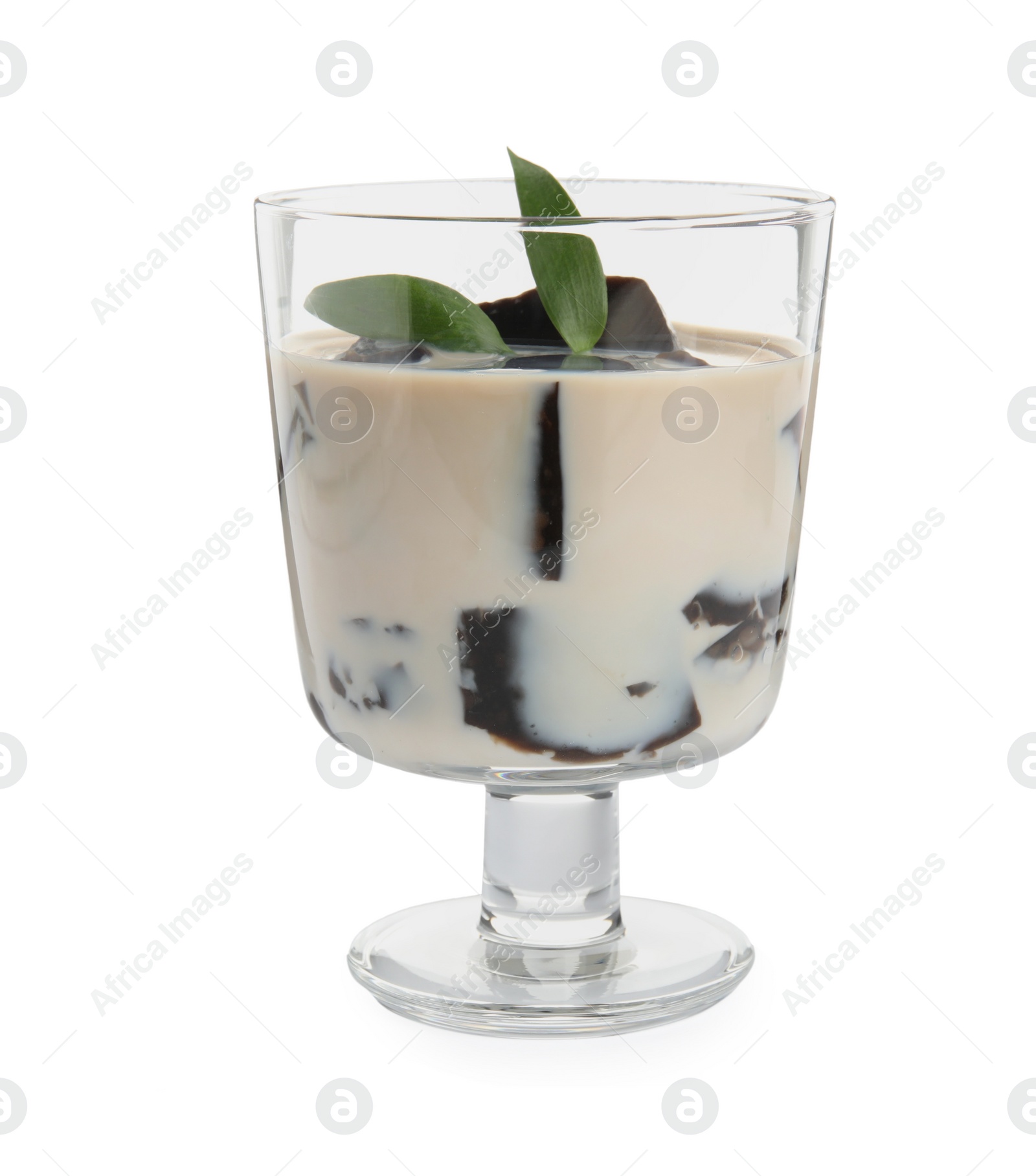 Photo of Glass of milk with grass jelly and green leaves isolated on white