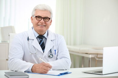 Photo of Portrait of senior doctor in white coat at workplace