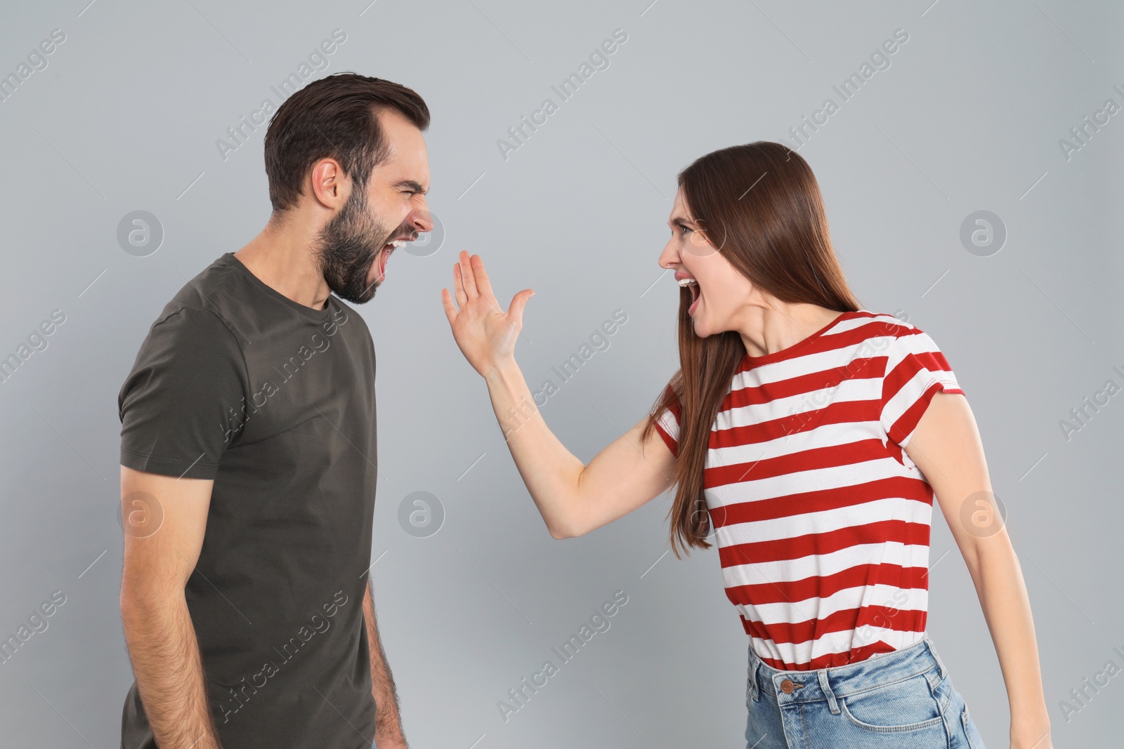 Photo of Couple quarreling on grey background. Relationship problems