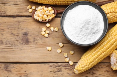 Photo of Bowl with corn starch, ripe cobs and kernels on wooden table, flat lay. Space for text
