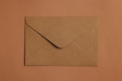 Photo of Envelope made of parchment paper on brown background, top view
