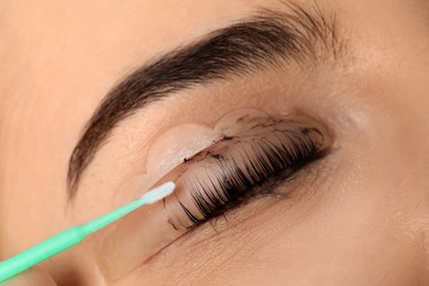 Photo of Young woman undergoing eyelash lamination and tinting, closeup