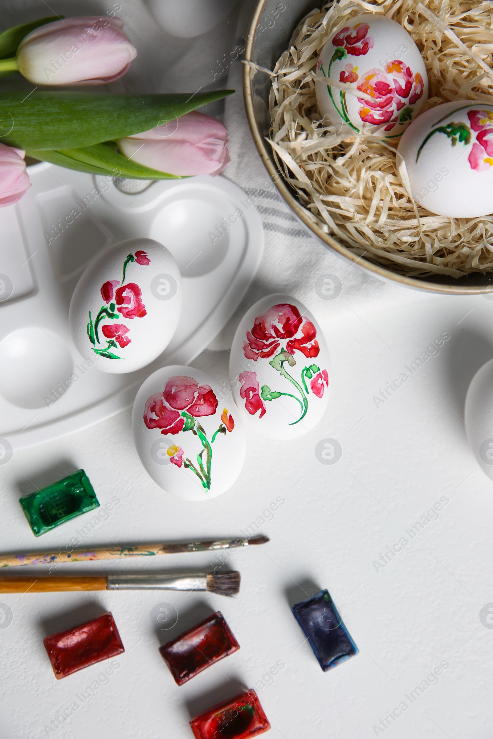 Photo of Painting Easter eggs on white table, flat lay