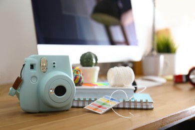 Photo of Digital camera and notebooks on table in studio. Modern designer's workplace