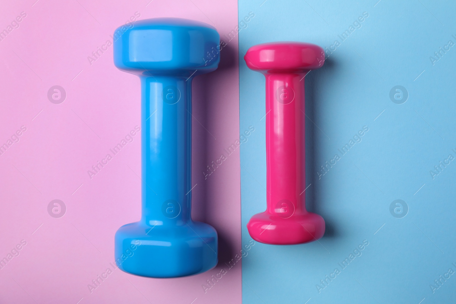 Photo of Bright dumbbells on color background, flat lay. Home fitness