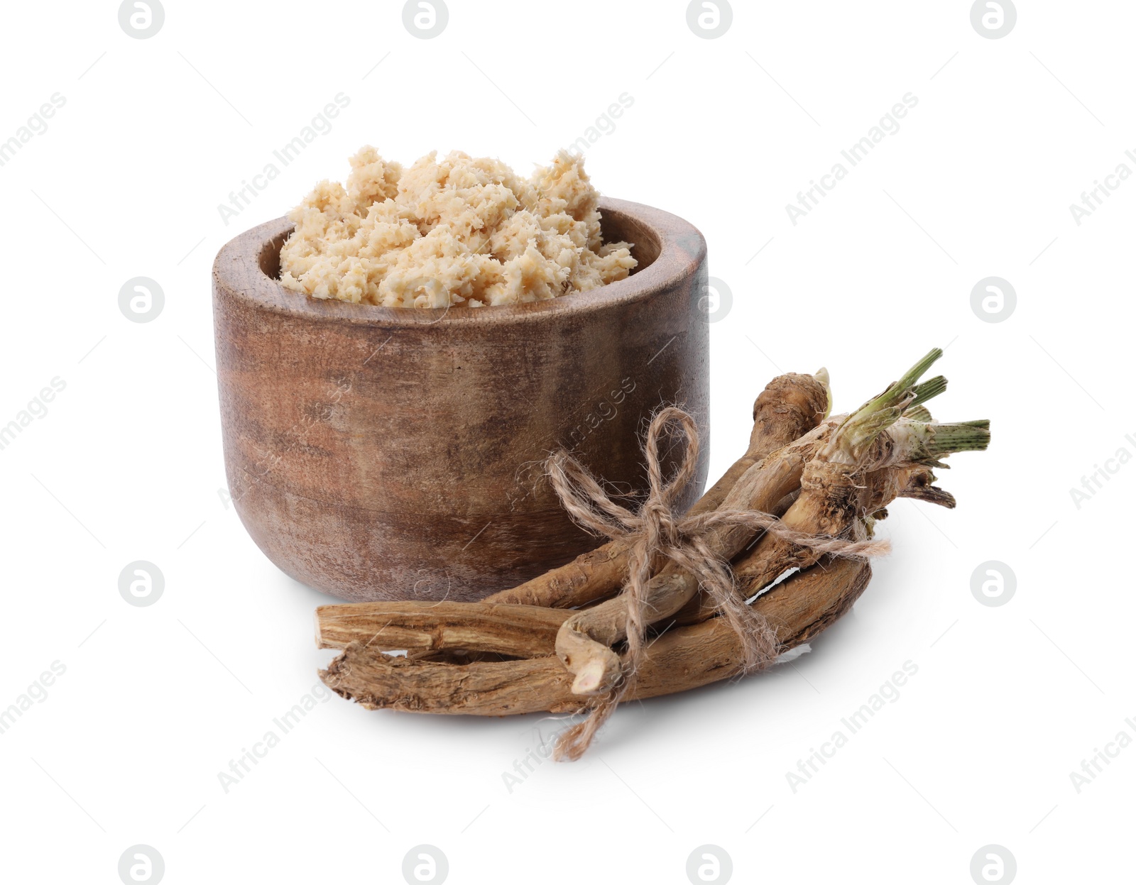 Photo of Bowl of tasty prepared horseradish and roots isolated on white