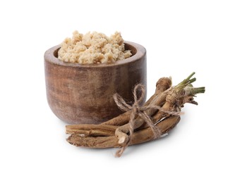 Bowl of tasty prepared horseradish and roots isolated on white