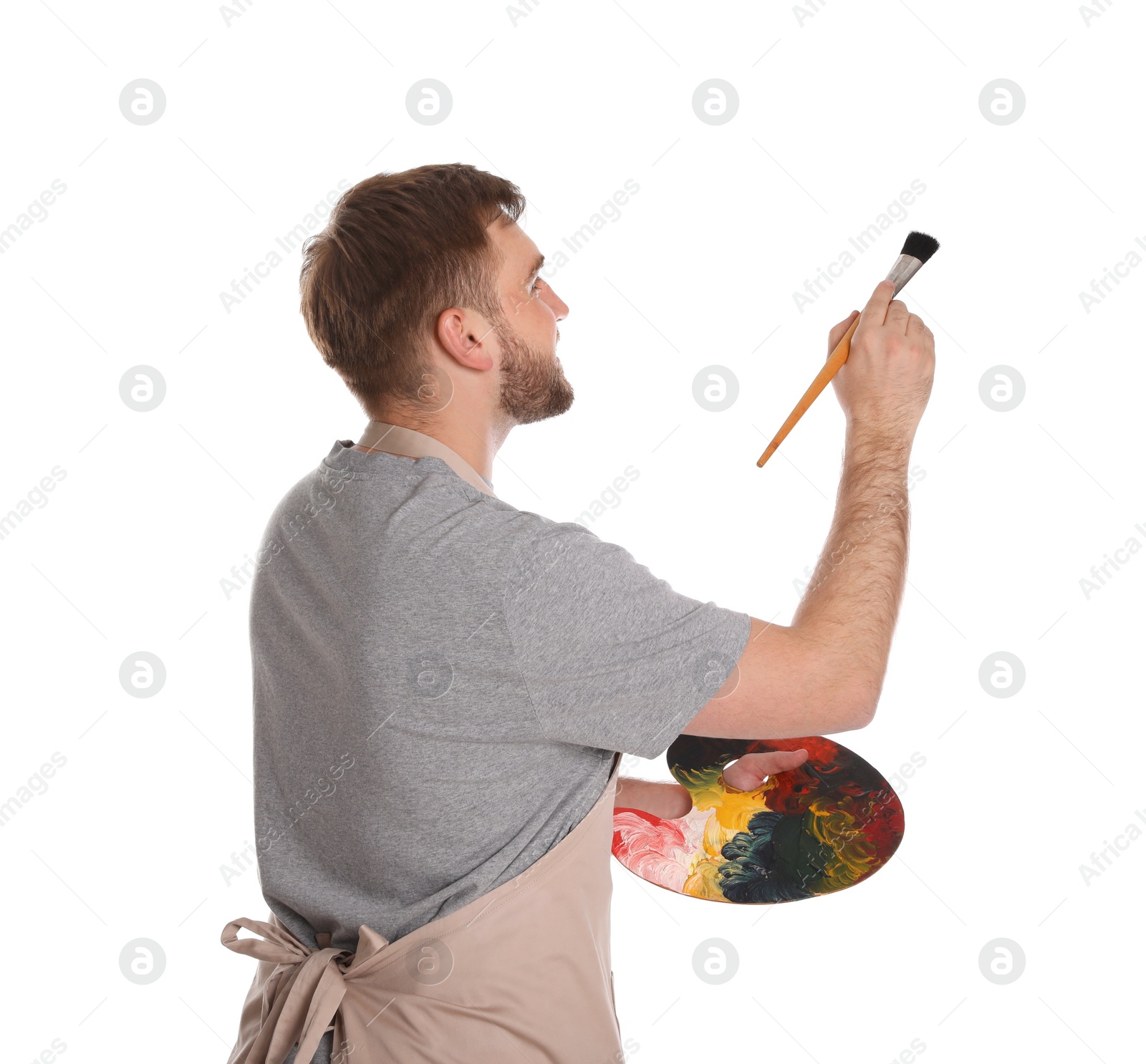 Photo of Man painting with brush on white background. Young artist