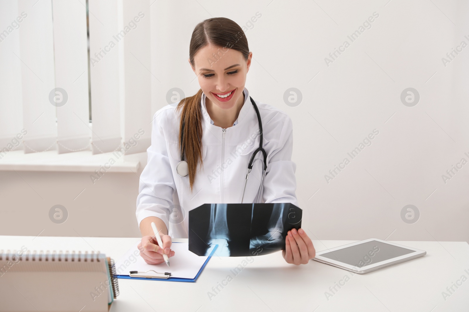 Photo of Orthopedist examining X-ray picture at desk in clinic