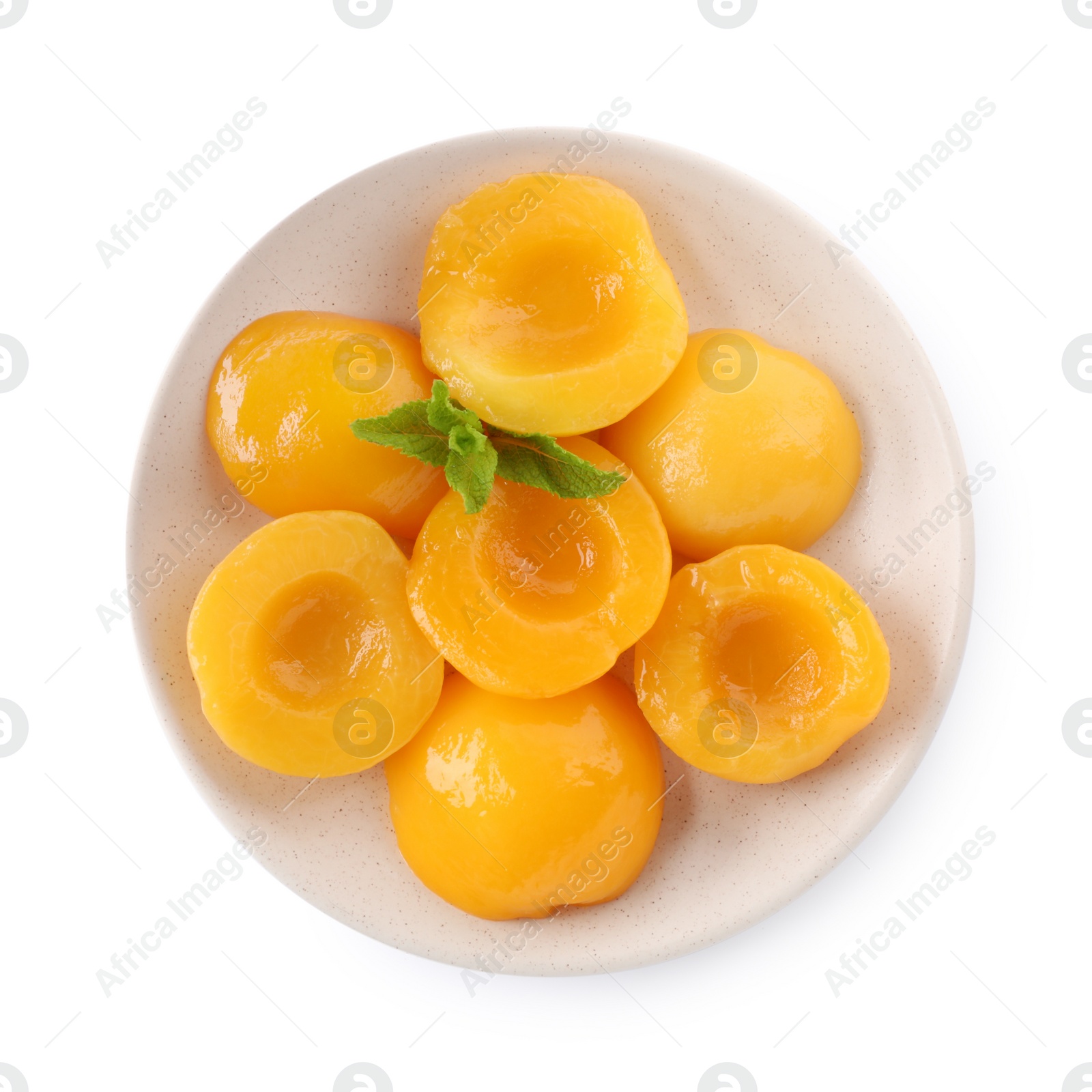 Photo of Halves of canned peaches with mint leaves isolated on white, top view