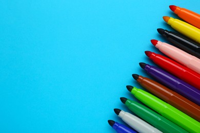 Photo of Many different colorful markers on light blue background, flat lay. Space for text